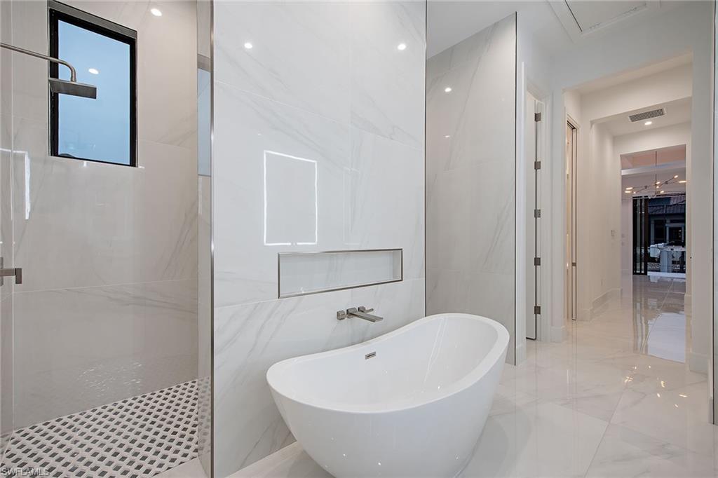 1840 Sandpiper Street Naples, FL 34102 - Photo 6 of 11 a bathroom with a white tub shower and vanity