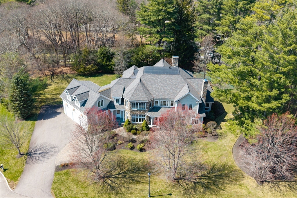 a aerial view of a house with swimming pool and large trees