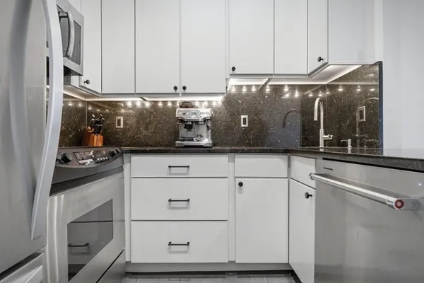 a kitchen with white cabinets and a stove