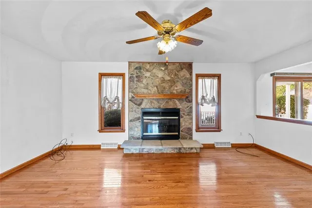 a view of a livingroom with wooden floor and a ceiling fan