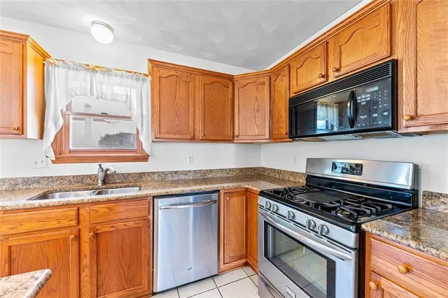 a kitchen with stainless steel appliances granite countertop a stove microwave sink and cabinets