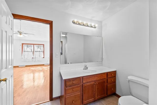 a spacious bathroom with a toilet sink and mirror
