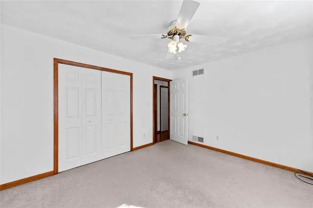 an empty room with a chandelier fan