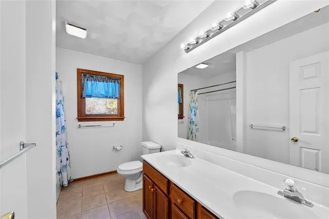 a en suite bathroom with a double vanity sink a mirror and a toilet