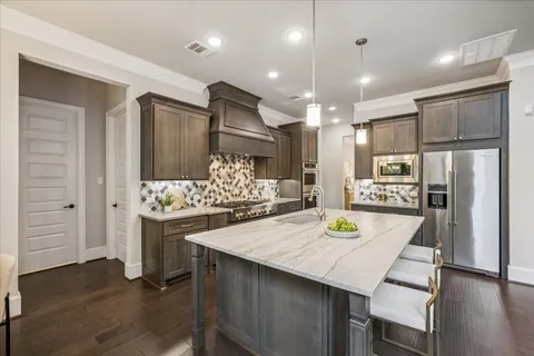 a kitchen with refrigerator and wooden floor