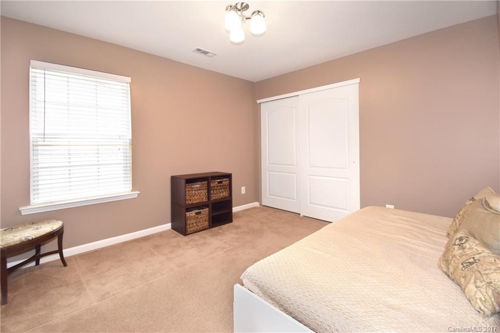 10010 Rocky Ford Club Road Charlotte, NC 28269 - Photo 15 of 24 a spacious bedroom with a bed and a chandelier