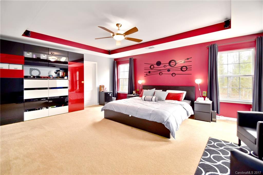 10010 Rocky Ford Club Road Charlotte, NC 28269 - Photo 19 of 24 a spacious bedroom with a bed and a chandelier