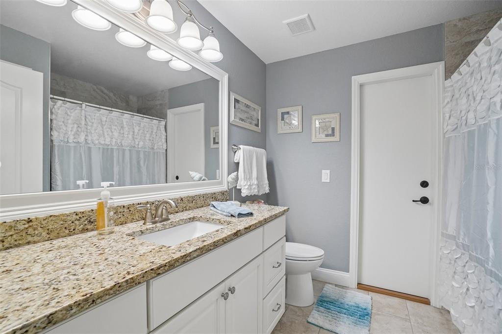 3934 Connersville Road Bartow, FL 33830 - Photo 46 of 81 a bathroom with a granite countertop sink a toilet and a shower