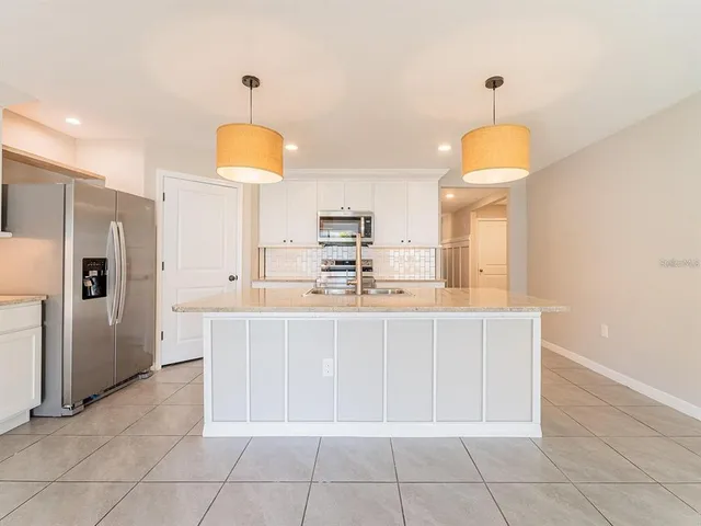 a kitchen with kitchen island granite countertop a sink a counter top space and cabinets
