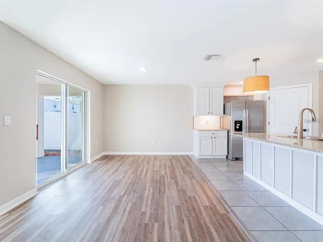 a view of a kitchen with wooden floor and electronic appliances