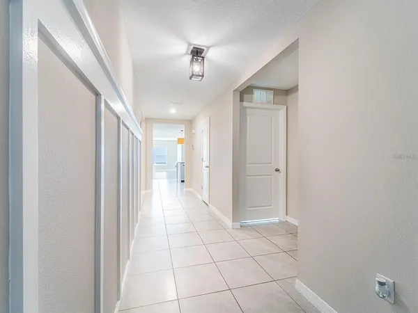 a view of a hallway with wooden floor and chandelier