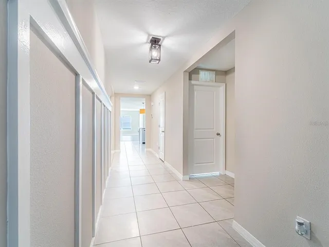 a view of a hallway with wooden floor and chandelier