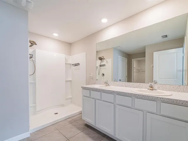 a bathroom with a shower sink vanity and mirror