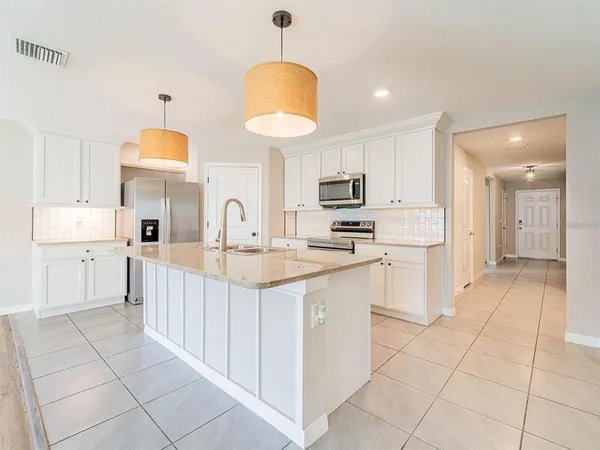 a kitchen with kitchen island granite countertop a sink counter top space appliances and cabinets