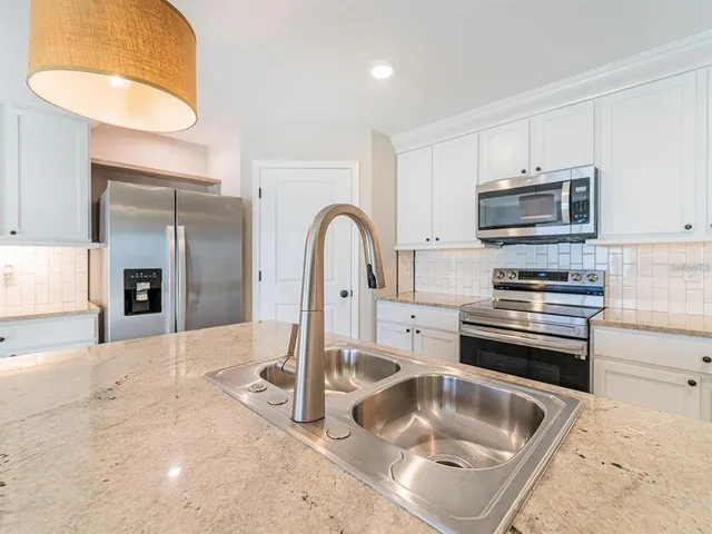 a kitchen with granite countertop a sink and a stove top oven