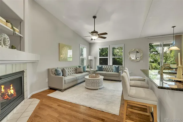 a living room with furniture a fireplace and a large window