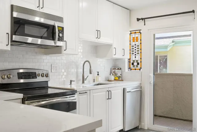 a kitchen with stainless steel appliances a stove a sink and a microwave