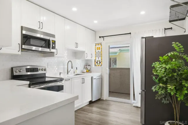 a kitchen with stainless steel appliances a stove a sink a refrigerator and a microwave