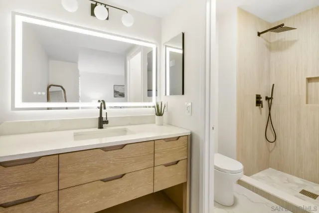 a bathroom with a sink toilet vanity and shower