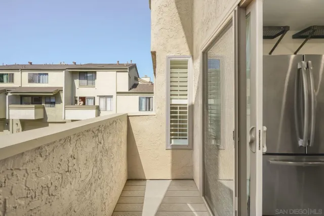 a view of kitchen with stainless steel appliances wooden floor and a window
