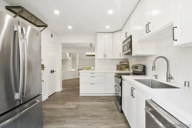 a kitchen with white cabinets and refrigerator