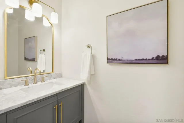 a bathroom with a granite countertop sink and a mirror
