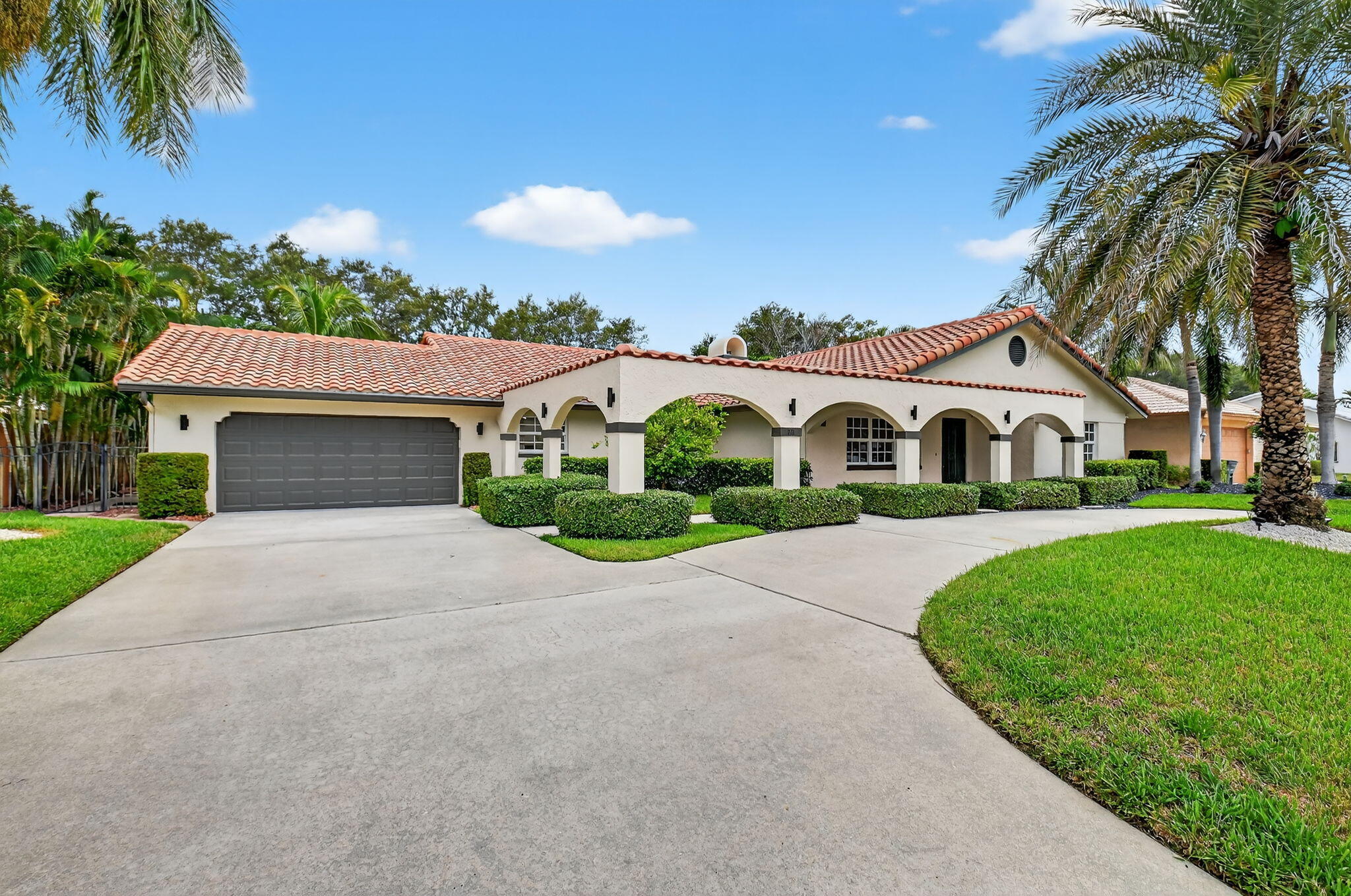 360 Northwest 53rd Street Boca Raton, FL 33487 - Photo 2 of 72 a front view of a house with a garden and yard