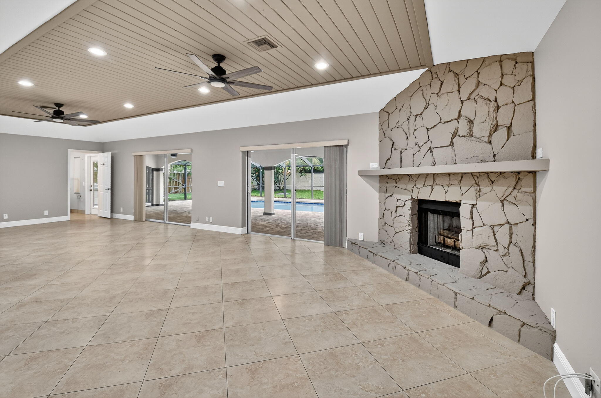 360 Northwest 53rd Street Boca Raton, FL 33487 - Photo 26 of 72 an empty room with a fireplace and chandelier