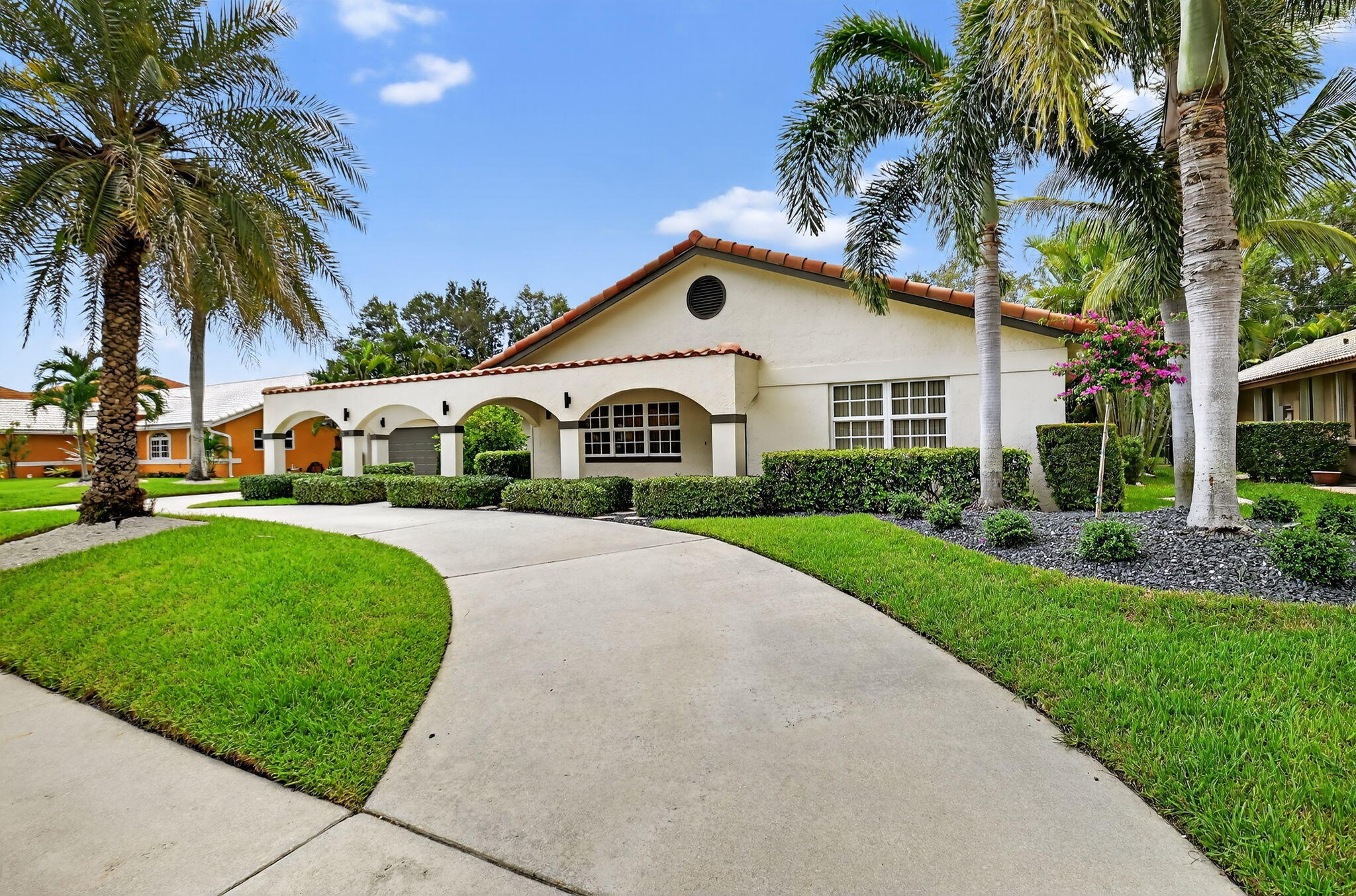 360 Northwest 53rd Street Boca Raton, FL 33487 - Photo 3 of 72 a front view of a house with a garden and palm trees