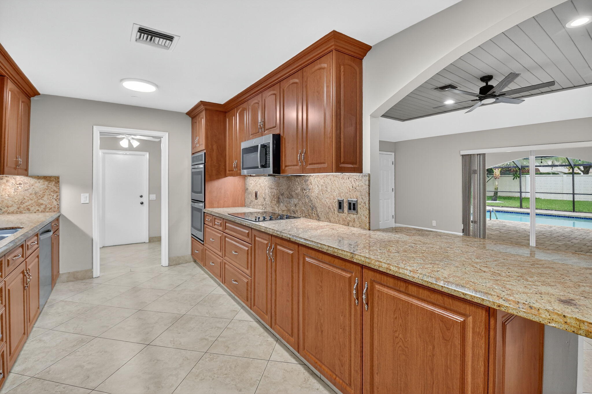 360 Northwest 53rd Street Boca Raton, FL 33487 - Photo 38 of 72 a large kitchen with stainless steel appliances granite countertop a sink and cabinets