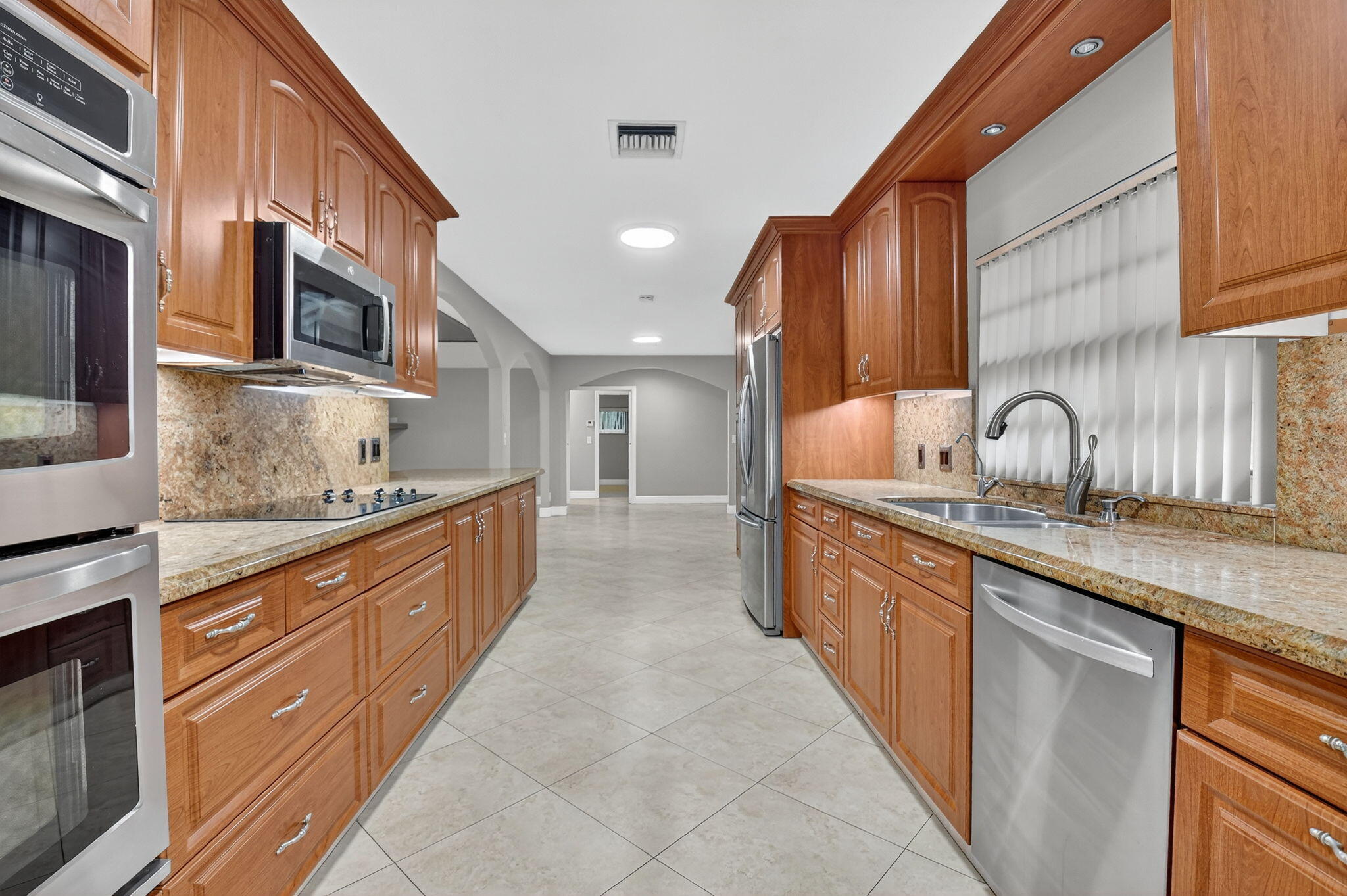 360 Northwest 53rd Street Boca Raton, FL 33487 - Photo 41 of 72 a kitchen with stainless steel appliances granite countertop a sink and stove top oven