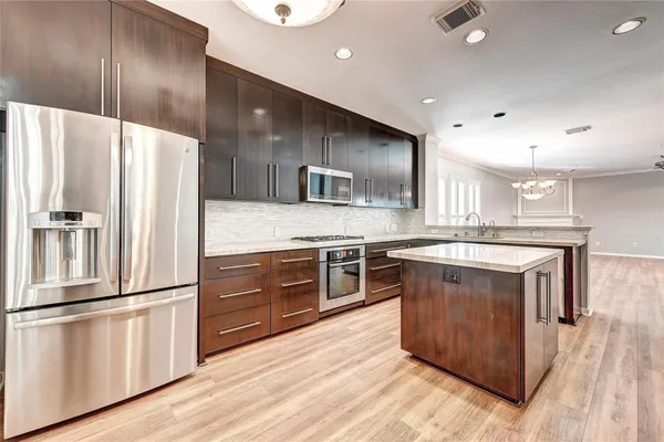 a kitchen with stainless steel appliances granite countertop a refrigerator a stove a sink and a refrigerator