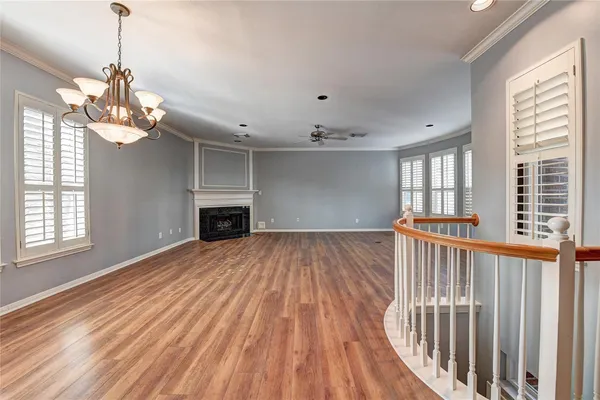 a view of a room with wooden floor fireplace and windows