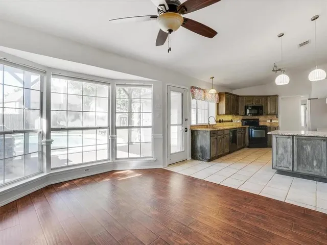 a view of kitchen with kitchen island wooden floor and stainless steel appliances