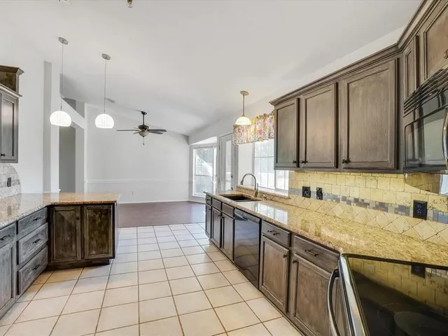 a spacious bathroom with a granite countertop sink a mirror and a bathtub