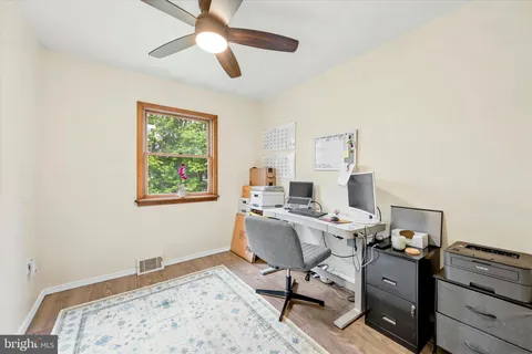 a view of a workspace with furniture and a window