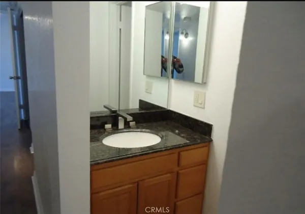a bathroom with a granite countertop sink and a mirror