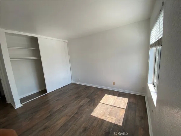 an empty room with wooden floor and entrance