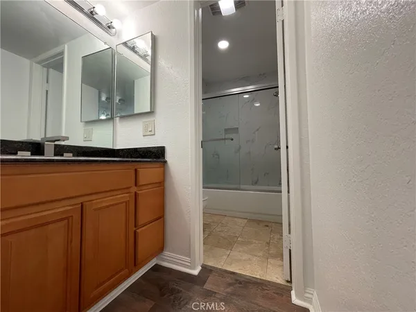 a bathroom with a sink a light fixture and a glass door