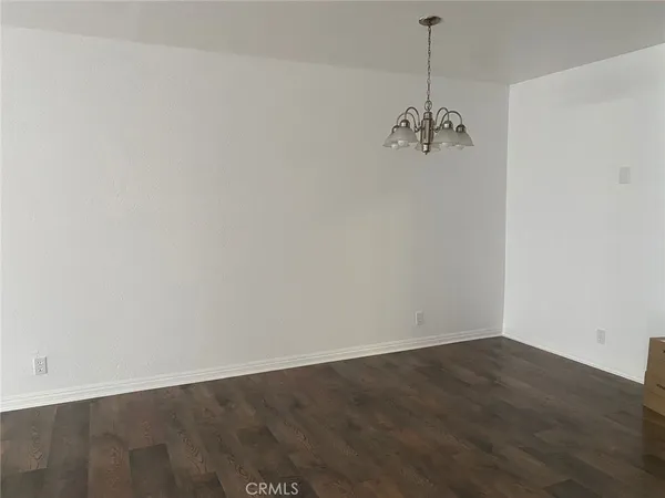 a view of a room with wooden floor and ceiling fan