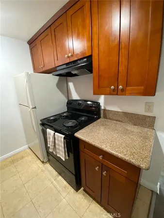 a kitchen with granite countertop cabinets and stove top oven
