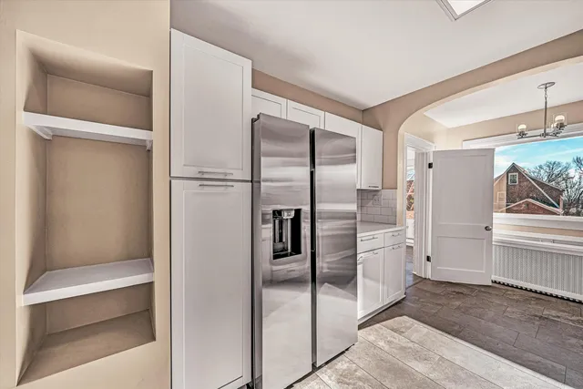a metallic refrigerator freezer sitting in a kitchen