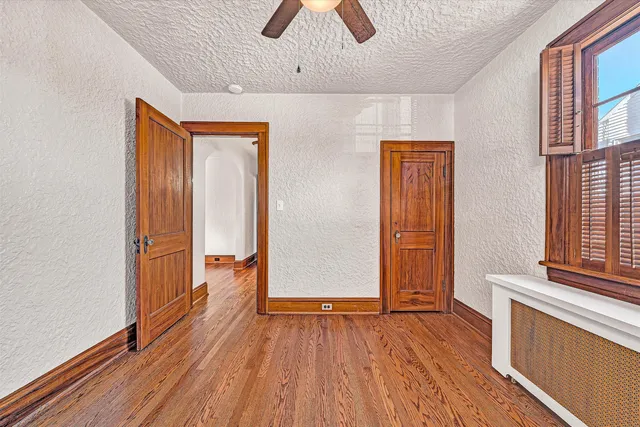 a view of empty room with wooden floor