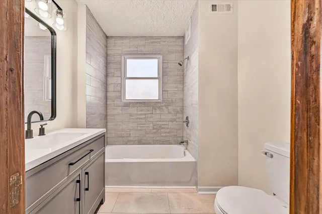 a bathroom with a granite countertop sink toilet and shower