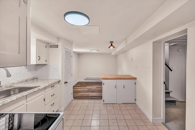 a view of a kitchen with white cabinets