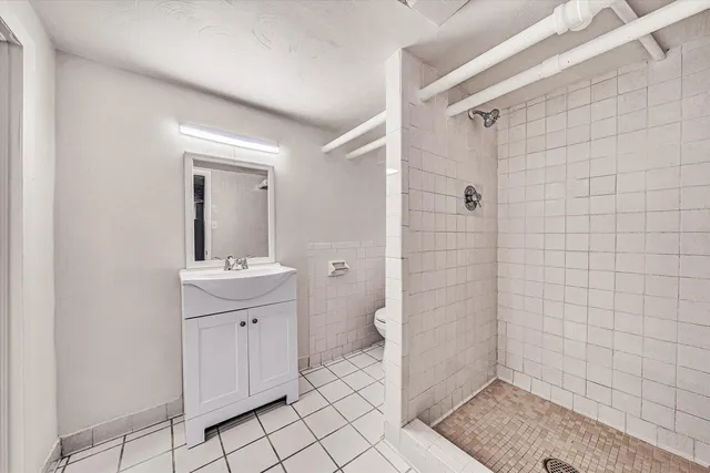 a bathroom with a sink a toilet and shower