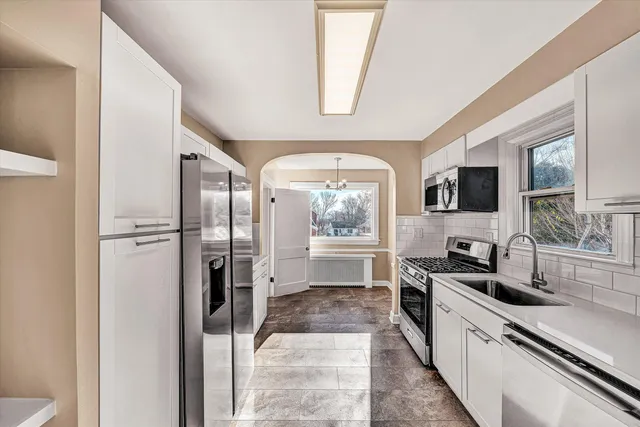 a large kitchen with a large window and stainless steel appliances