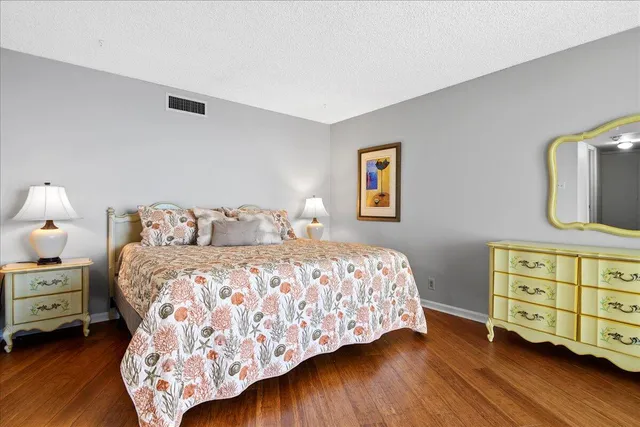 a spacious bedroom with two beds and painting on the wall