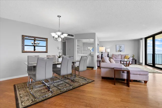 a living room with furniture a chandelier and a flat screen tv