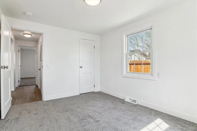 an empty room with windows and closet